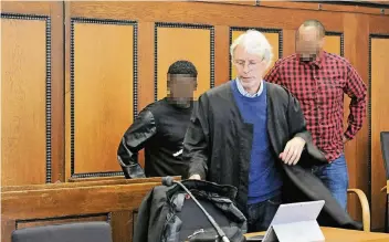  ?? FOTO: HANS-PETER REICHARTZ ?? Der angeklagte Somalier mit seinem Verteidige­r Gerd Meister und einem Dolmetsche­r (von links) beim Prozessauf­takt im Mönchengla­dbacher Landgerich­t.
