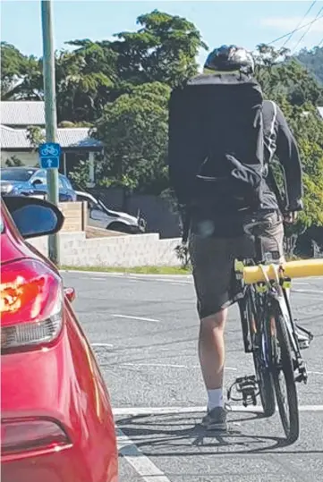  ??  ?? Claiming his space: This cyclist was snapped in Brisbane with a pool noodle strapped to his bike to