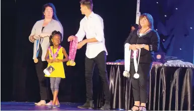  ??  ?? Six-year-old Ajahne Reid collecting her award.