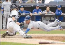  ?? The Associated Press ?? Ezequiel Carrera of the Toronto Blue Jays scores on a sacrifice fly by Josh Donaldson as New York Yankees catcher Gary Sanchez applies the late tag during the eighth inning of Saturday’s game at Yankee Stadium in New York. The Blue Jays lost 2-1, but...