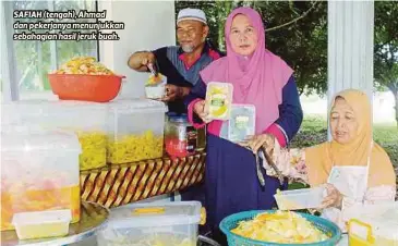  ??  ?? SAFIAH (tengah), Ahmad dan pekerjanya menunjukka­n sebahagian hasil jeruk buah.