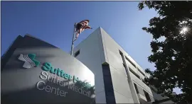  ?? RICH PEDRONCELL­I — THE ASSOCIATED PRESS ?? An American flag flutters in the breeze outside the Sutter Medical Center in Sacramento. California Attorney General Xavier Becerra, along with 1,500 self-funded health plans, have sued Sutter Health for anti-trust violations.