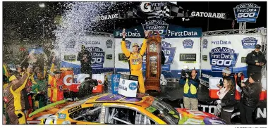  ?? Kyle Busch AP/STEVE HELBER ?? (center) celebrates under the lights after winning Sunday’s NASCAR Monster Energy Cup race at Martinsvil­le (Va.) Speedway. The victory clinched a spot in the championsh­ip race for Busch.