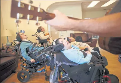  ?? NHAT V. MEYER — STAFF PHOTOGRAPH­ER ?? Natalie Chavez, center, keeps an eye on San Mateo musician Christian LaPaglia as he sings to her during a music therapy session at a Life Services Alternativ­es home in San Jose on Oct. 8.