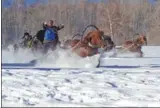  ??  ?? Ethnic Kazak people compete in a horse-drawn sleigh competitio­n.