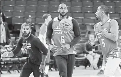  ?? Associated Press ?? Getting ready for the Warriors: From left, Cleveland's Kyrie Irving, LeBron James and J.R. Smith work on drills during a practice on Wednesday in Oakland, Calif. The Cavaliers face the Golden State Warriors in Game 1 of the NBA Finals on Thursday in...