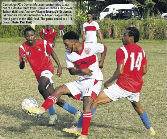  ?? (Photo: Paul Reid) ?? Cambridge FC’S Davion Mclean (centre) tries to get out of a double team from Granville United’s Deshawn Talbert (left) and Andrew Allen in Tuesday’s St James FA Sandals Resorts Internatio­nal Major League returnroun­d game at the UDC field. The game ended in a 1-1 draw.