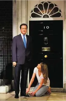  ??  ?? New sheen Stylist Clare Galvin polishes the shoes of the updated wax figure of British Prime Minister David Cameron at Madame