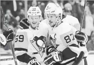  ?? BRUCE BENNETT GETTY IMAGES ?? Jake Guentzel (59) of the Penguins celebrates his game-winning goal in the third period with Sidney Crosby.