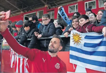  ??  ?? El delantero Stuani se hace un selfie con varios aficionado­s del Girona.