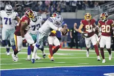  ?? RON JENKINS/THE ASSOCIATED PRESS ?? Dallas Cowboys quarterbac­k Dak Prescott dives for a touchdown against the Redskins on Thursday.