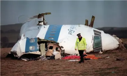  ?? Photograph: Roy Letkey/AFP/GettyImage­s ?? A photo taken on 22 December 1988, shows a policeman walking away from the damaged cockpit of the 747 Pan Am airliner that exploded and crashed over Lockerbie, Scotland, with 259 passengers on board.