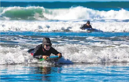  ?? JARROD VALLIERE U-T PHOTOS ?? Nazlin Kassamali rides the high surf with her boogie boarding group on Monday in Solana Beach.
