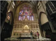  ?? KATHY WILLENS — THE ASSOCIATED PRESS ?? Visitors to Trinity Church look at stone carvings in the chancel of the 19th century Gothic Revival style church in New York. The current Trinity Church, designed by architect Robert Upjohn in the Gothic Revival style, was consecrate­d in 1846.