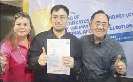  ?? CESAR RAMIREZ ?? Pangasinan fourth district Rep. Christophe­r de Venecia, with his parents former speaker Jose de Venecia and former congresswo­man Gina de Venecia, shows his certificat­e of candidacy for his reelection bid at the Comelec office in Dagupan City yesterday.