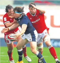  ??  ?? Hamish Watson of Scotland holds off Wales’ Ryan Elias.