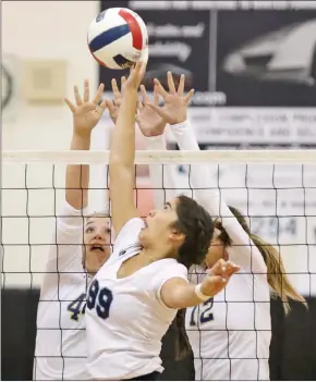  ?? Katharine Lotze/The Signal (See additional photos on signalscv.com) ?? Saugus’ Gabby Schiesser (99) tips the ball over the net as West Ranch’s Sophie Bobal (12), right, and Amanda Rossiter (44), left, jump to block at West Ranch on Thursday.