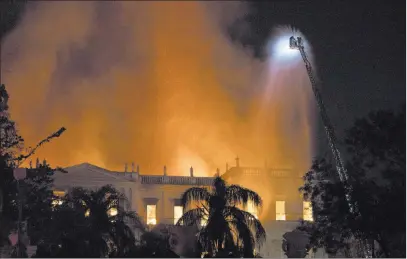  ?? Leo Correa ?? The Associated Press Firefighte­rs work Sunday to douse the flames at the 200-year-old National Museum of Brazil in Rio de Janeiro. According to its website, the museum held thousands of items related to the history of Brazil and other countries.