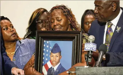 ?? GERALD HERBERT/AP ?? Chantemekk­i Fortson, mother of Roger Fortson, a U.S. Navy airman who is from Atlanta and graduated from McNair High School, holds a photo of her son. He was shot to death by a sheriff’s deputy in Florida who came to his apartment on a complaint.