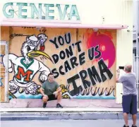  ??  ?? A tourist poses for a picture outside of a shop in South Beach prior to the arrival of Hurricane Irma to south Florida, on Saturday.