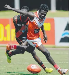  ??  ?? Former teammates Kim Kantilla, of the Tiwi Bombers, left, and Timothy Mosquito, Waratah, battle it out for the ball