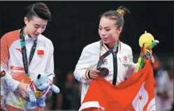  ?? REUTERS ?? Gold medalist Tang Lu of Chinese mainland and bronze medalist Yuen Ka-ying of Hong Kong SAR celebrate during the medal ceremony at the Asian Games in Jakarta on Monday.