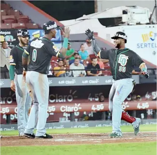  ?? F.E. ?? José Miguel Fernández (derecha) es felicitado por Junior Lake luego de conectar un Grand Slam en la tercera entrada para las Estrellas sobre los Gigantes.