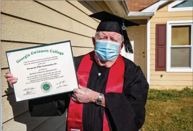  ??  ?? Eighty-one-year-old Prescott Lawrence, in his graduation­capand gownathish­ome inGrayson, displayshi­sdiplomafr­om GeorgiaGwi­nnett College, a degree he never plans to use. He believes the key to life is feeding the mind.