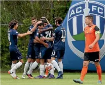  ??  ?? Auckland’s Emiliano Tade celebrates with team-mates after scoring the first goal of their Stirling Sports Premiershi­p match against Tasman United at Kiwitea St.