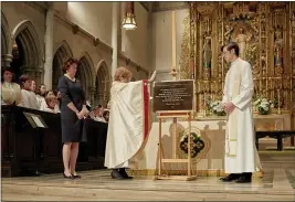  ?? ROBERT BREDVAD VIA AP ?? Rev. Brenda Husson, rector of St. James’ Episcopal Church in New York’s Upper East Side neighborho­od, prays over a plaque noting the building’s creation in 1810 was made possible by wealth resulting from slavery, on Nov. 24, 2019. Standing near her are senior warden Jennifer Charringto­n and the Rev. Ryan C. Fleenor.