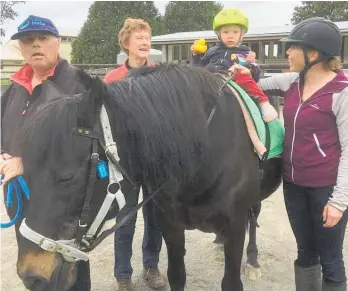  ??  ?? Levin RDA volunteers Rodney and Brenda work with rider Caileigh on Cruze while mum Alieta looks on.