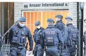  ?? FOTO: DPA ?? Polizeibea­mte stehen vor dem Gebäude des Vereins Ansaar Internatio­nal an der Worringer Straße.