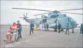  ?? PTI ?? Navy shifts three people rescued from Barge P305 by a Seaking helicopter for medical attention at INS Shikra, in Mumbai on Tuesday .