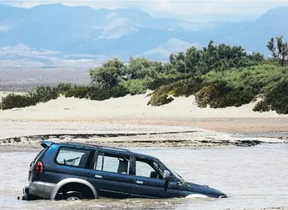  ?? Julián Jaén / EFE ?? Un coche fue arrastrado hasta al mar por las lluvias caídas en el parque natural del cabo de Gata