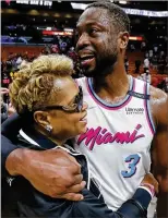  ?? WILFREDO LEE / AP ?? Heat guard Dwyane
Wade hugs his mother, Jolinda Wade, after scoring a season-high 27 points, including 15 of the team’s final 17 points, all coming in the final 4:57 Tuesday against the 76ers.