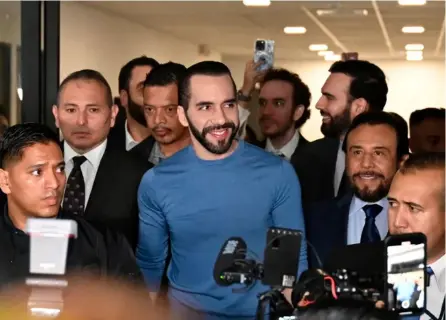  ?? AFP ?? El presidente de El Salvador, Nayib Bukele (centro), sonríe al llegar a la sede del Tribunal Supremo Electoral cuando se registró para las nuevas elecciones, en San Salvador.