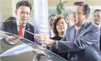  ??  ?? Liow scanning the QR code on a vehicle tint film during launch of the Malaysia Vehicle Tint Film Standardis­ation Mechanism at the Transport Ministry in Putrajaya yesterday.