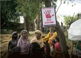  ??  ?? Le long de cette même route, les Rohingyas profitent du passage des convois D’ONG pour faire passer des messages politiques.