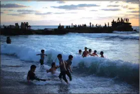  ?? (AP/Khalil Hamra) ?? Palestinia­n children play in the water June 4 as the sun sets over the beach of Gaza City.