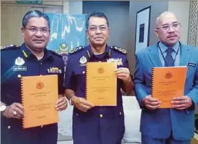  ??  ?? Road Transport Department director-general Datuk Shaharuddi­n Khalid (centre) showing a copy of ‘Notes on RTD Governance Towards TN50’ in Kuala Lumpur yesterday.