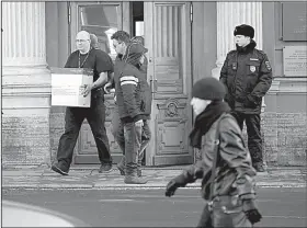  ?? AP/DMITRI LOVETSKY ?? A man carries boxes from the U.S. Consulate in St. Petersburg, Russia, as a Russian police officer guards the entrance Friday.