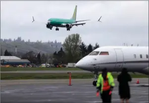  ?? The Associated Press ?? COCKPIT CONFUSION: A Boeing 737 MAX 8 airplane being built for India-based Jet Airways, top, lands following a test flight on April 10 at Boeing Field in Seattle. Federal safety officials say Boeing should consider how cockpit confusion can slow the response of pilots who are dealing with the kind of problem that likely caused two airliners to crash in the past year.