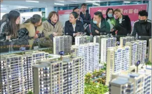  ?? WEI LIANG / CHINA NEWS SERVICE ?? Potential homebuyers look at property models in Taiyuan, Shanxi province.