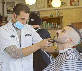  ?? AP ?? A customer at a barber shop gets a shave after coronaviru­s restrictio­ns were eased, opening shopping centers, gyms, barber shops, among other sites in Jerusalem on Tuesday.