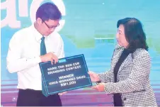  ?? — Bernama photo ?? Zaimah (right) presents a gift to a BSN Care recipient, Idris Mohamed Daud yesterday after launching the BSN CARE brand yesterday.