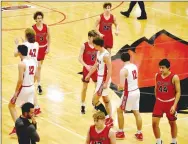  ?? Pea Ridge Times photograph by Mark Humphrey ?? Pea Ridge head coach Trent Loyd and five reserve players (from left) in red jerseys, Colton Thurman (No. 3), Jeffery Beck (No. 2), Brittin Game (No. 22), Seth Foster (No. 12) and Jeriah Gamez (No. 44), found themselves with the privilege of extending sportsmans­hip to Farmington senior manager, Seth Adams (white jersey No. 12), a special needs player dressing out for the game. Adams made a free throw and a 3-pointer in the fourth of quarter of the Cardinals’ 77-47 win on Friday, Feb. 11.