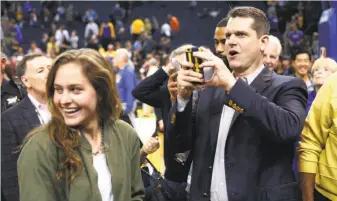  ?? Beck Diefenbach / Special to The Chronicle ?? Michigan head coach Jim Harbaugh takes photos at the Thunder-Warriors game Feb. 6, the night before the former 49ers head coach was a spectator at the Super Bowl at Levi’s Stadium.