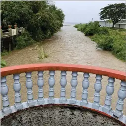  ?? RICK CRUZ/PACIFIC DAILY VIA AP ?? The Laelae River in Umatac, Guam, becomes swollen with rain runoff Tuesday as Super Typhoon Mawar approaches. Rainfall of 10 to 15 inches or more is possible. Serious flooding and landslides are likely. Winds of 130 to 150 mph or higher are likely to lead to widespread power outages across the island.