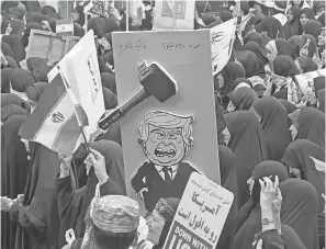  ?? ATTA KENARE/ AFP/ GETTY IMAGES ?? A placard mocking President Donald Trump during a rally Monday outside the former U. S. embassy in Tehran.