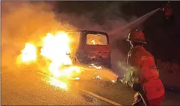  ?? Rick McClure/For The Signal ?? L.A. County firefighte­rs hose down an SUV on Sierra Highway Thursday morning.